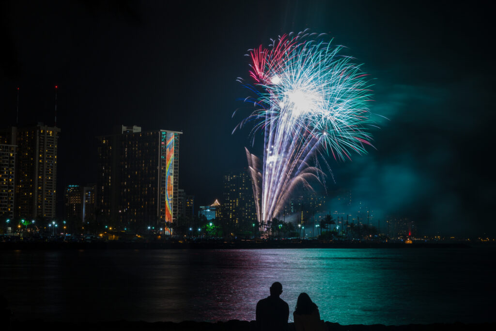 Colorful fireworks in Waikiki over the water with hotels in the background