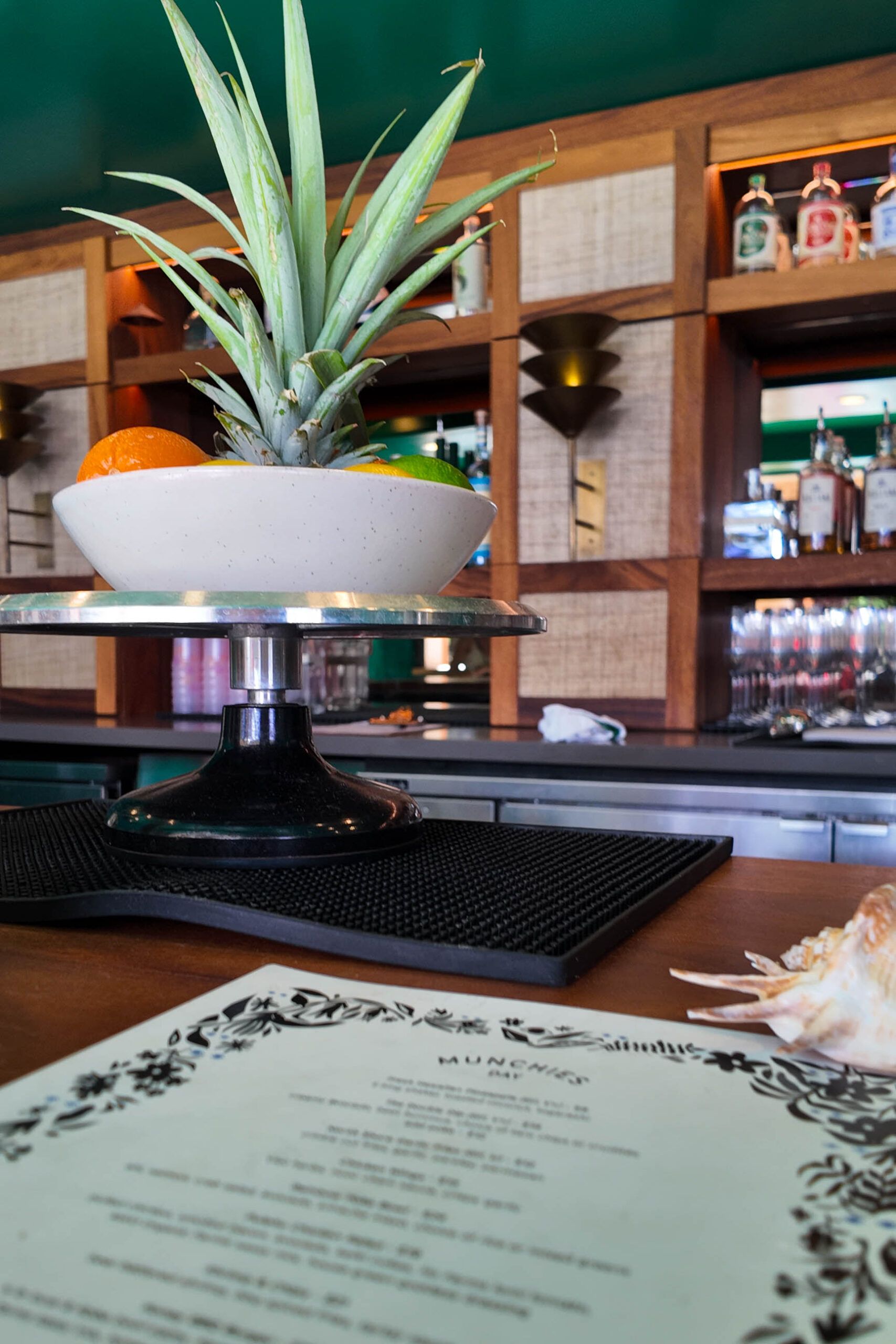 A bar with a menu on it and a bowl of fruit
