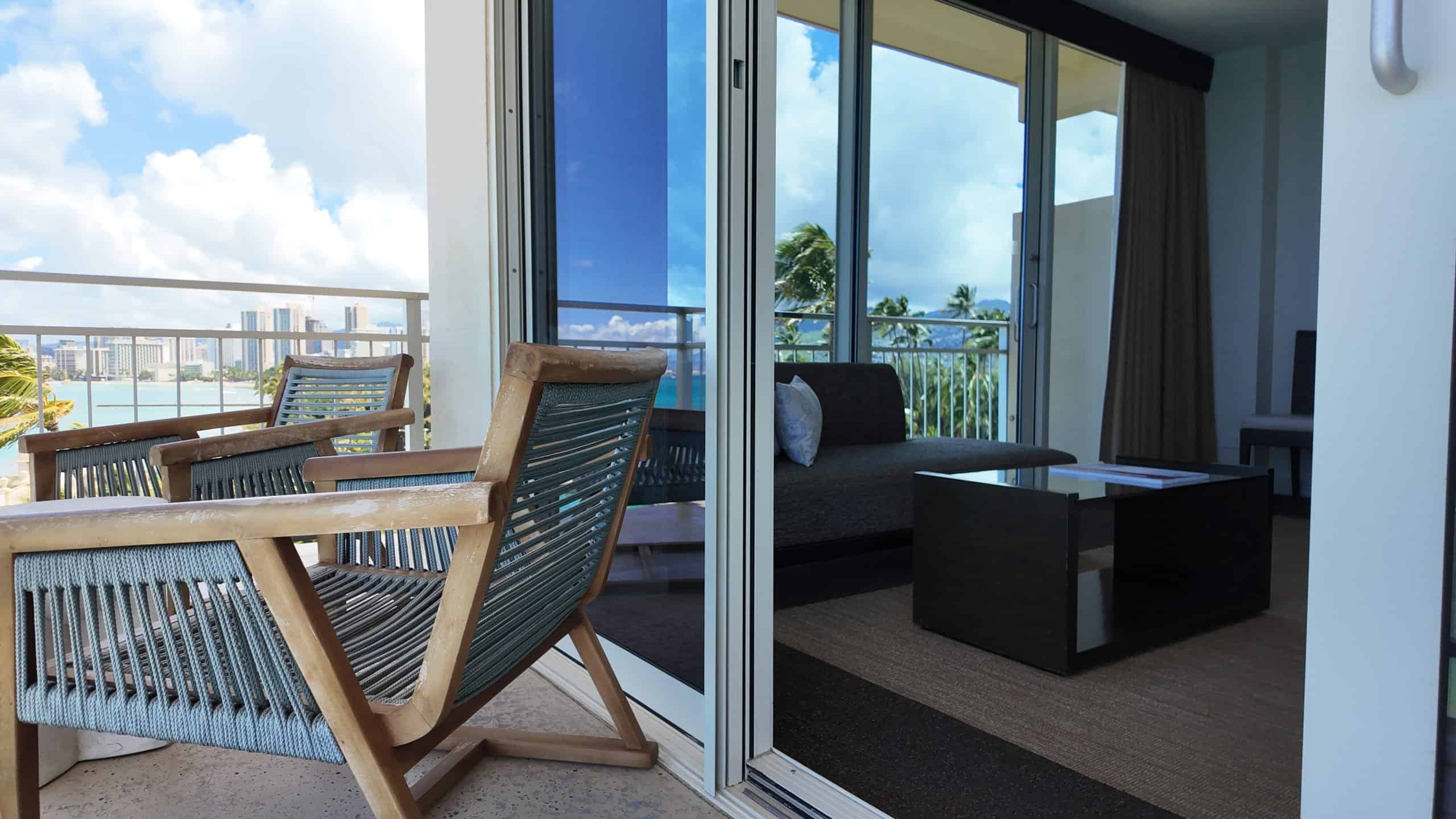 Patio chairs looking into a hotel room.