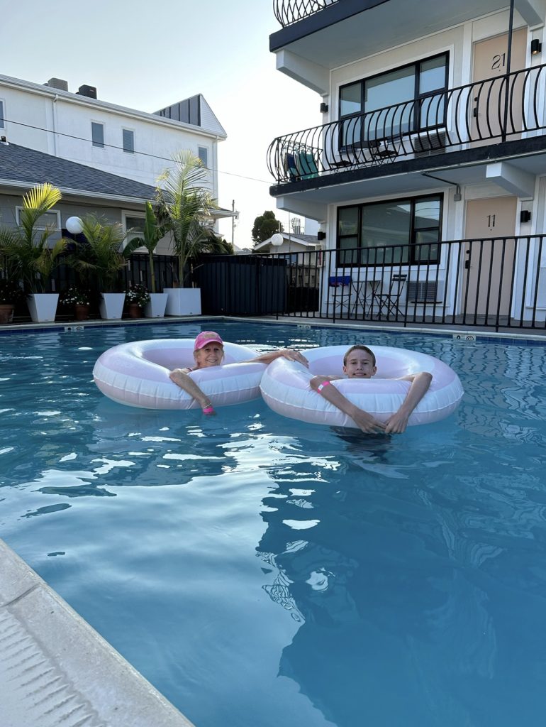 A woman and a boy in pool floats at a hotel