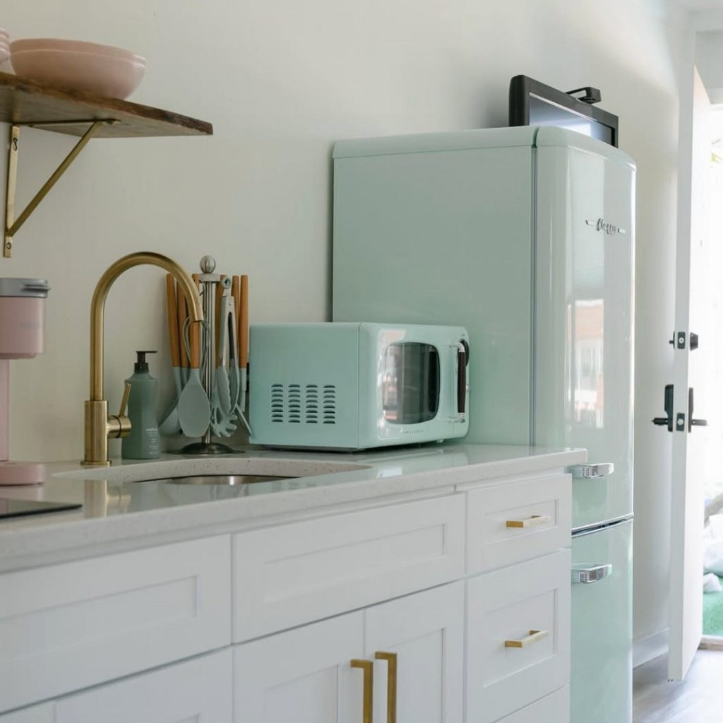 A small kitchen with retro turquoise appliances in The Shore House apartment style hotel